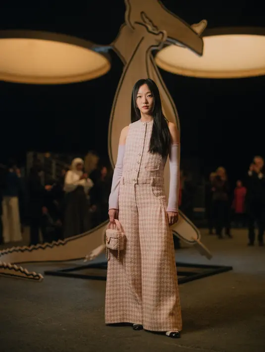 Gaya Kim Go-Eun bertolak belakang dengan G-Dragon. Jika G-Dragon tampil monokromatik hitam putih, ia memakai jumpsuit pastel motif plaid khas Chanel. [chanel]