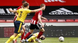 Pemain Arsenal Alexandre Lacazette (bawah) terjatuh setelah dilanggar saat menghadapi Sheffield United pada putaran keenam Piala FA di Bramall Lane, Sheffield, Inggris, Minggu (28/6/2020). Arsenal melaju ke semifinal Piala FA usai menaklukkan Sheffield United 2-1. (Andrew Boyers/Pool via AP)