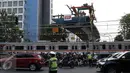 Kereta Commuter melintas di bawah proyek flyover Permata Hijau, Jakarta, Selasa (6/10/2015). Pelintasan kereta api di Permata Hijau yang menuju ke arah Patal Senayan akan ditutup karena pengerjaan struktur di atas pelintasan. (Liputan6.com/Yoppy Renato)