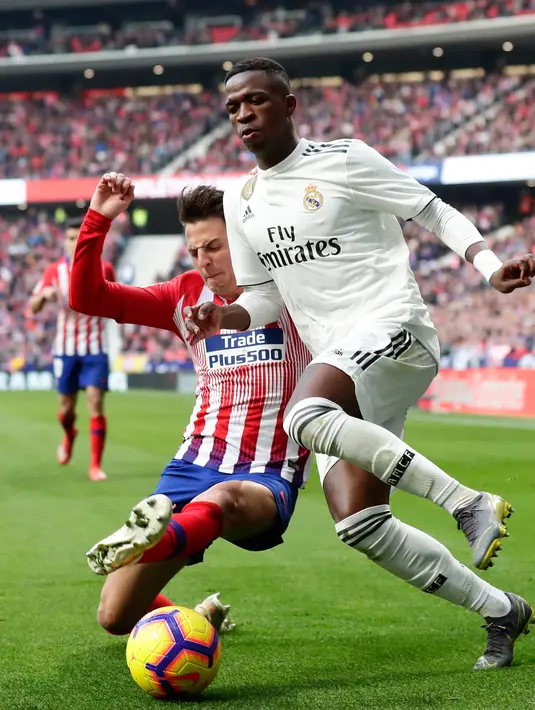 Striker Real Madrid, Vinicius Junior berusaha melewati Bek Atletico Madrid, Santiago Arias selama pertandingan lanjutan La Liga Spanyol di stadion Wanda Metropolitano (9/2). Real Madrid menang 3-1 atas Atletico. (AP Photo/Manu Fernandez)