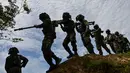 Sejumlah prajurit TNI dari batalyon infantri Raider 112 berjalan membawa senjata berat untuk latihan menembak di Mata Ie, Aceh Besar, Aceh, Selasa (11/6/2019). Latihan ini untuk menjaga keutuhan negara dari ancaman serta gangguan baik dari dalam maupun luar negeri. (AFP Photo/Chaideer Mahyuddin)