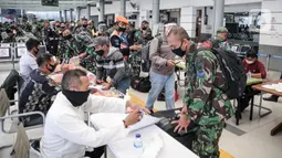 Calon penumpang melapor kepada petugas di Stasiun Pasar Senen, Jakarta, Jumat (10/7/2020). PT KAI telah mengoperasikan lima perjalanan kereta jarak jauh untuk tujuan Bandung, Cirebon, dan Surabaya mulai Jumat 10 Juli 2020. (Liputan6.com/Faizal Fanani)