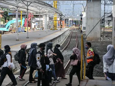 Calon penumpang kereta listrik Commuterline (KRL) saat melintas di dekat proyek pembangunan Stasiun Manggarai, Jakarta, Rabu (22/2/2023). Kepala Balai Teknik Perkeretaapian Wilayah Jakarta-Banten Rode Paulus mengungkapkan, pembangunan Stasiun Manggarai sisi timur tahap II ditargetkan akan selesai 2023. (merdeka.com/Iqbal S Nugroho)