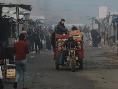 Seorang pria mengemudikan kendaraan saat pagi hari yang diselimuti kabut di Khan Yunis, Jalur Gaza utara pada Jumat 17 Januari 2025. (Bashar TALEB/AFP)