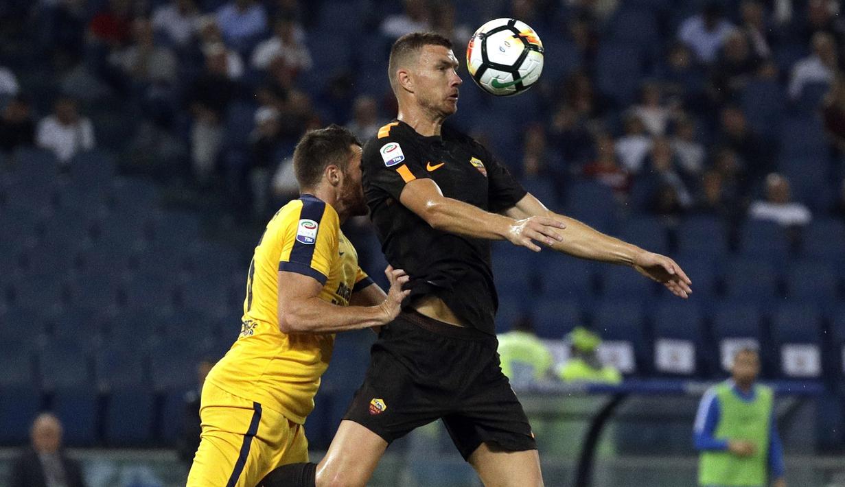 Aksi Edin Dzeko (kanan) menahan bola saat berduel dengan pemain Hellas Verona pada lanjutan Serie A di Olympic stadium, Roma, (16/9/2017). Roma menang 3-0. (AP/Andrew Medichini)