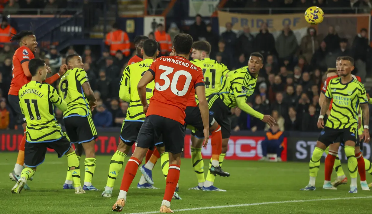 Bek Luton Town, Gabriel Osho (kiri) melepaskan sundulan ke gawang Arsenal yang berbuah gol penyeimbang 1-1 pada laga lanjutan pekan ke-15 Liga Inggris 2023/2024 di Kenilworth Road, Luton, Rabu (6/12/2023) dini hari WIB. (AP Photo/Ian Walton)