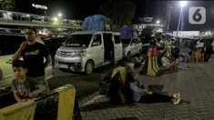 Aktivitas sejumlah pemudik saat sedang menunggu waktu masuk ke dalam kapal penyeberangan di Pelabuhan Merak, Banten, Jumat (28/3/2025). (Liputan6.com/Herman Zakharia)