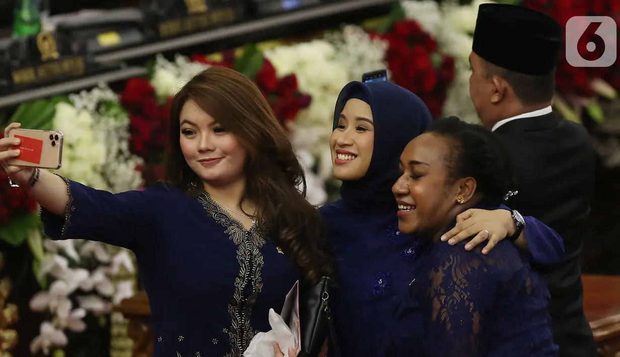 Anggota DPR Hillary Brigitta Lasut berselfie saat menghadiri pelantikan Presiden dan Wapres 2019 di Gedung MPR/DPR/DPD RI, Senayan, Jakarta, Minggu (20/10/2019). Jokowi-Ma'ruf Amin resmi dilantik sebagai Presiden dan Wapres RI periode 2019-2024. (Liputan6.com/Johan Tallo)