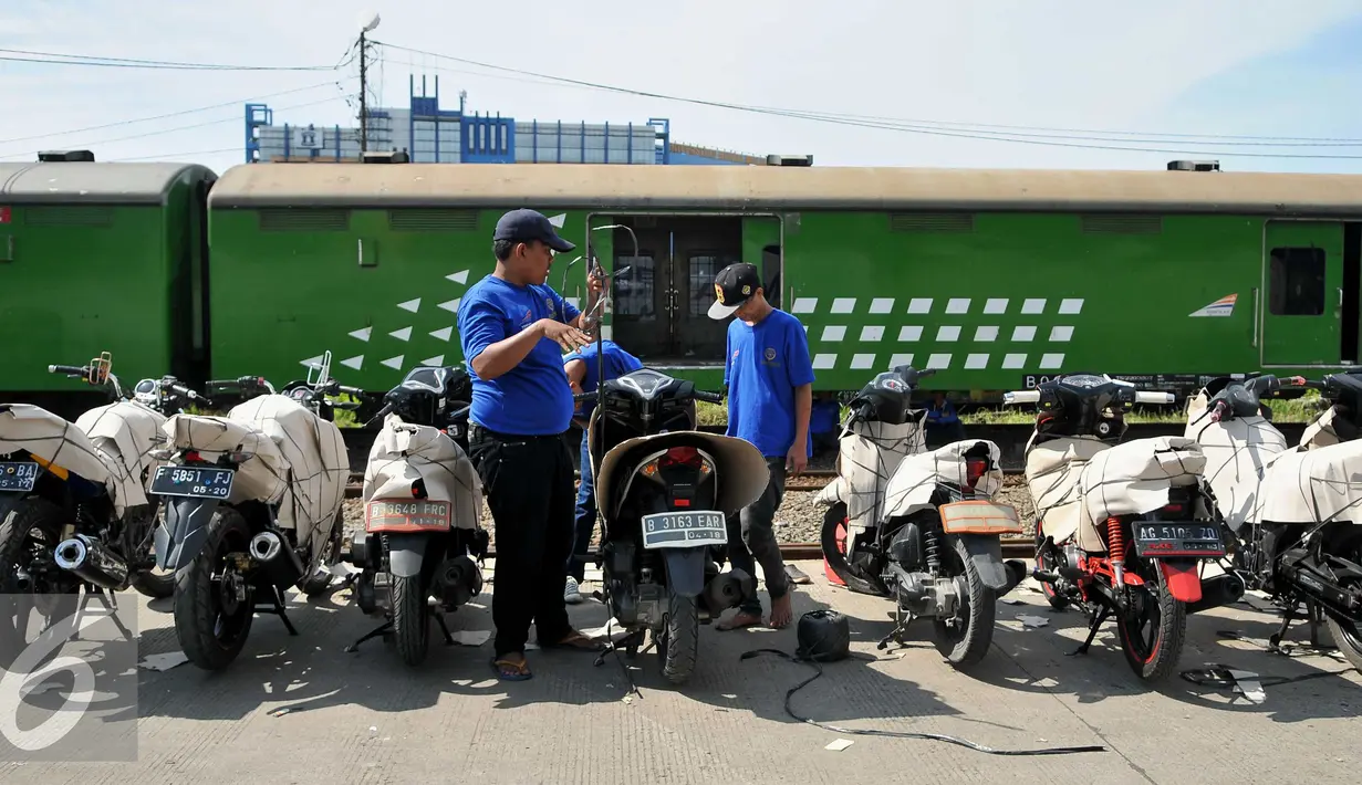 Pekerja menata sepeda motor yang akan dikirim melalui jasa pengiriman kereta api di Stasiun Jakarta Gudang, Rabu (16/7). PT KAI menyediakan 35 gerbong guna angkutan motor gratis lebaran tahun 2016. (Liputan6.com/Gempur M Surya)