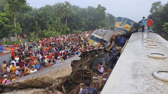 Tabrakan Kereta di Bangladesh: Warga berkumpul dekat gerbong kereta yang rusak parah setelah dua kereta bertabrakan di Distrik Brahmanbaria, 82 kilometer (51 mil) timur Dhaka, Bangladesh, Selasa (12/11/2019). Sekitar 16 orang tewas dan 60 lainnya terluka akibat kecelakaan tersebut. (AP Photo)