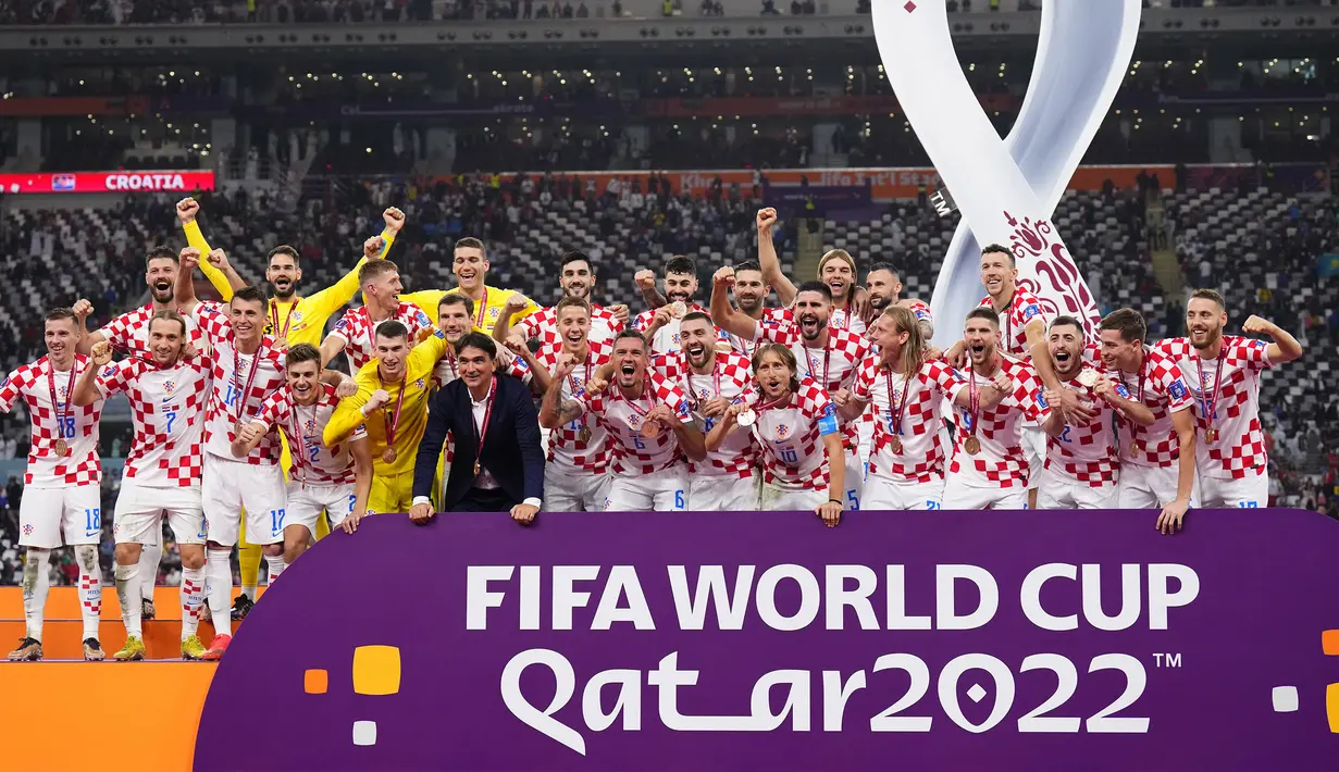Sejumlah pemain dan pelatih Kroasia merayakan kegembiraan setelah pengalungan medali peringkat ketiga Piala Dunia 2022 di Khalifa International Stadium, Minggu (18/12/2022). (AP Photo/Hassan Ammar)