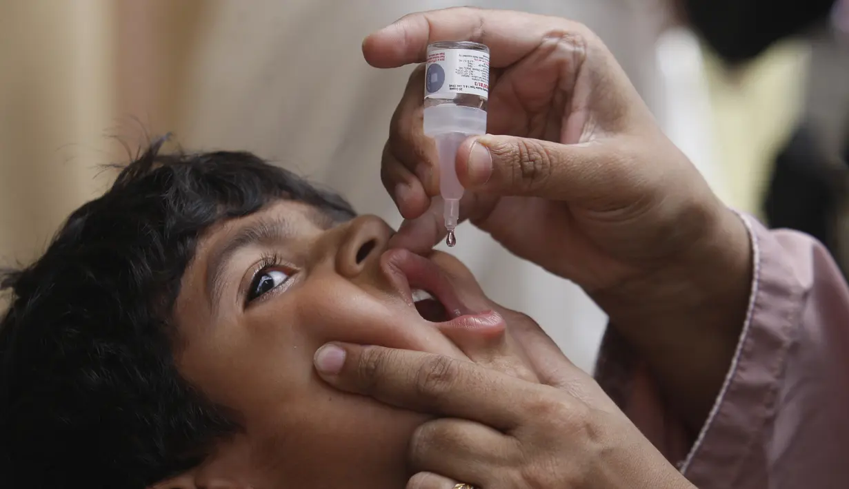 <p>Seorang petugas kesehatan memberikan vaksin polio kepada seorang anak di Karachi, Pakistan, Senin (23/5/2022). Pakistan meluncurkan upaya anti-polio baru pada hari Senin, lebih dari seminggu setelah pejabat mendeteksi kasus ketiga tahun ini di wilayah barat laut negara itu yang berbatasan dengan Afghanistan. (AP Photo/Fareed Khan)</p>