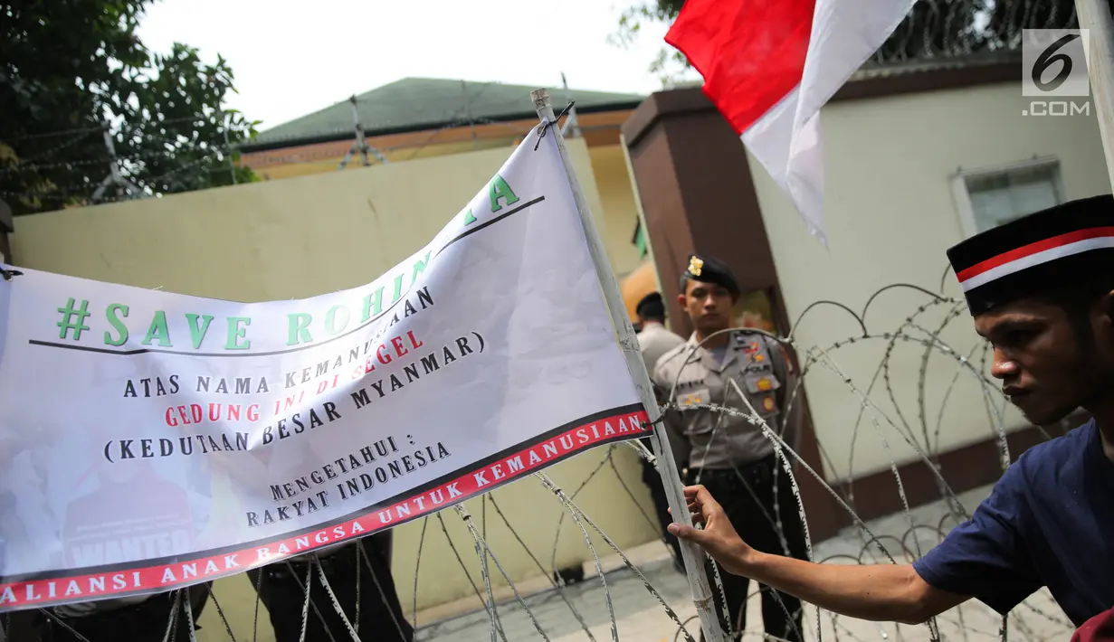 Massa Aliansi Anak Bangsa untuk Kemanusiaan memasang spanduk sebagai tanda penyegelan di depan Kedubes Myanmar, Jakarta, Selasa (5/9). Mereka menggelar aksi demonstrasi dan doa bersama dalam rangka bela Muslim Rohingya. (Liputan6.com/Faizal Fanani)