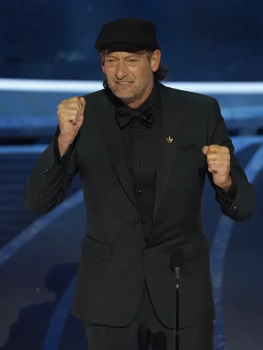 Troy Kotsur menyampaikan sambutan dalam bahasa isyarat usai menerima penghargaan aktor pendukung terbaik di atas panggung Academy Award ke-94 di Dolby Theatre di Hollywood, Minggu (27/3/2022). Kotsur berhasil cetak sejarah menjadi aktor tuli pertama yang memenangkan Oscar. (AP Photo/Chris Pizzello)