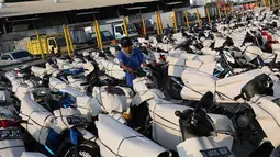 Petugas mengemas sepeda motor untuk diangkut dengan kereta api Stasiun Kampung Bandan, Jakarta, Senin (11/6). Program mudik gratis ini digagas Kemenhub tersebut melayani pengiriman ke beberapa daerah di Pulau Jawa. (Liputan6.com/Immanuel Antonius)
