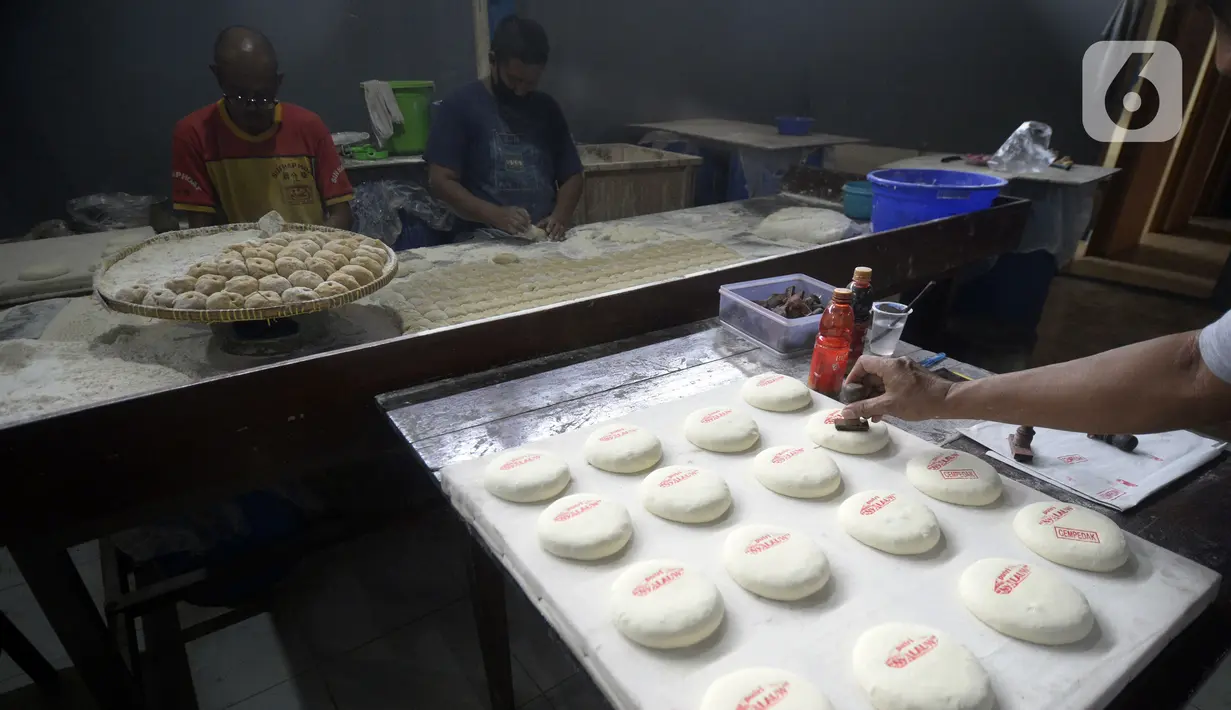 Pekerja menyelesaikan pembuatan kue bulan di Industri Rumahan Kue Bulan Putri Lauw, Pondok Sentul, Ciater, Tangerang Selatan, Selasa (10/11/2020). Pada masa pandemi sekarang, produksi kue tradisional khas Tionghoa tersebut menurun sesuai pesanan pembeli. (merdeka.com/Dwi Narwoko)