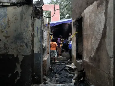 Warga berada di sisa rumah pasca kebakaran yang melahap permukiman di Jalan Kebon Sayur, Bidara Cina, Jakarta, Minggu (27/5). Sedikitnya 43 rumah warga di RT 007 dan 008 RW 014 di Bidara Cina ludes dilalap api. (Merdeka.com/Iqbal S Nugroho)