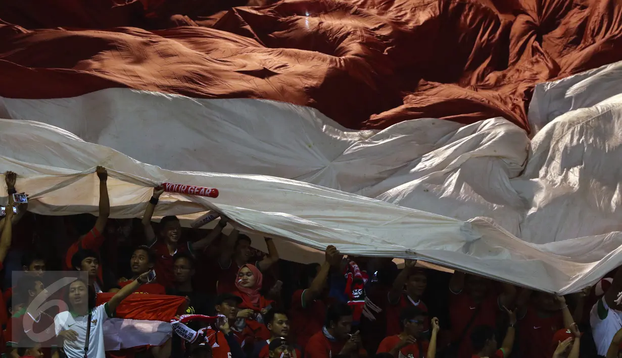 Suporter membentangkan bendera raksasa saat menyaksikan laga Timnas Indonesia melawan Vietnam pada semifinal pertama Piala AFF 2016 di Stadion Pakansari, Bogor, Sabtu (3/12). Indonesia unggul 2-1 atas Vietnam. (Liputan6.com/Helmi Fithriansyah)