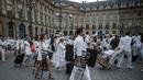 Peserta membawa kursi dan perlengkapan lain ketika mengikuti 'Diner en blanc' atau 'Makan Malam Putih' di Place Vendome, Paris, Rabu (8/6). Untuk  mendapatkan undangan, peserta harus mengenal seorang anggota organisasi Diner en Blanc. (PHILIPPE LOPE/AFP)