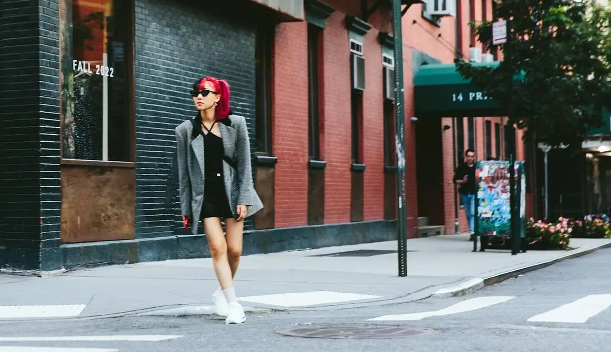 <p>Isyana tampak menikmati momen kesehariannya dengan mengenakan oversized blazer abu-abu. Sebagai innerwear, Isyana mengenakan tank top dengan model kerah halter dan mini skirt hitam. Penampilan semi formalnya ini semakin manis dengan tambahan sneakers berwarna putih. Foto: Instagram.</p>
