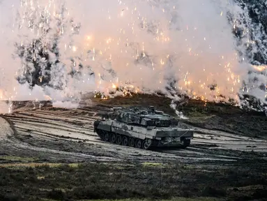 Sebuah tank Leopard 2 beraksi saat kunjungan Menteri Pertahanan Jerman Boris Pistorius ke batalyon tank Bundeswehr 203 di Field Marshal Rommel Barracks, Augustdorf, Jerman, 1 Februari 2023. Setelah keputusan pemerintah Jerman untuk mengirimkan 14 tank Leopard 2 ke Ukraina, kemampuan tank tempur utama Leopard 2A6 ditampilkan pada presentasi di Augustdorf. (AP Photo/Martin Meissner)