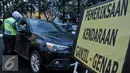 Petugas Kepolisian melakukan penilangan kepada pelanggar ganjil genap di Bundaran HI, Jakarta, Selasa (30/8). Sejumlah kendaraan masih didapati melanggar aturan ganjil genap yang telah resmi diberlakukan. (Liputan6.com/Yoppy Renato)