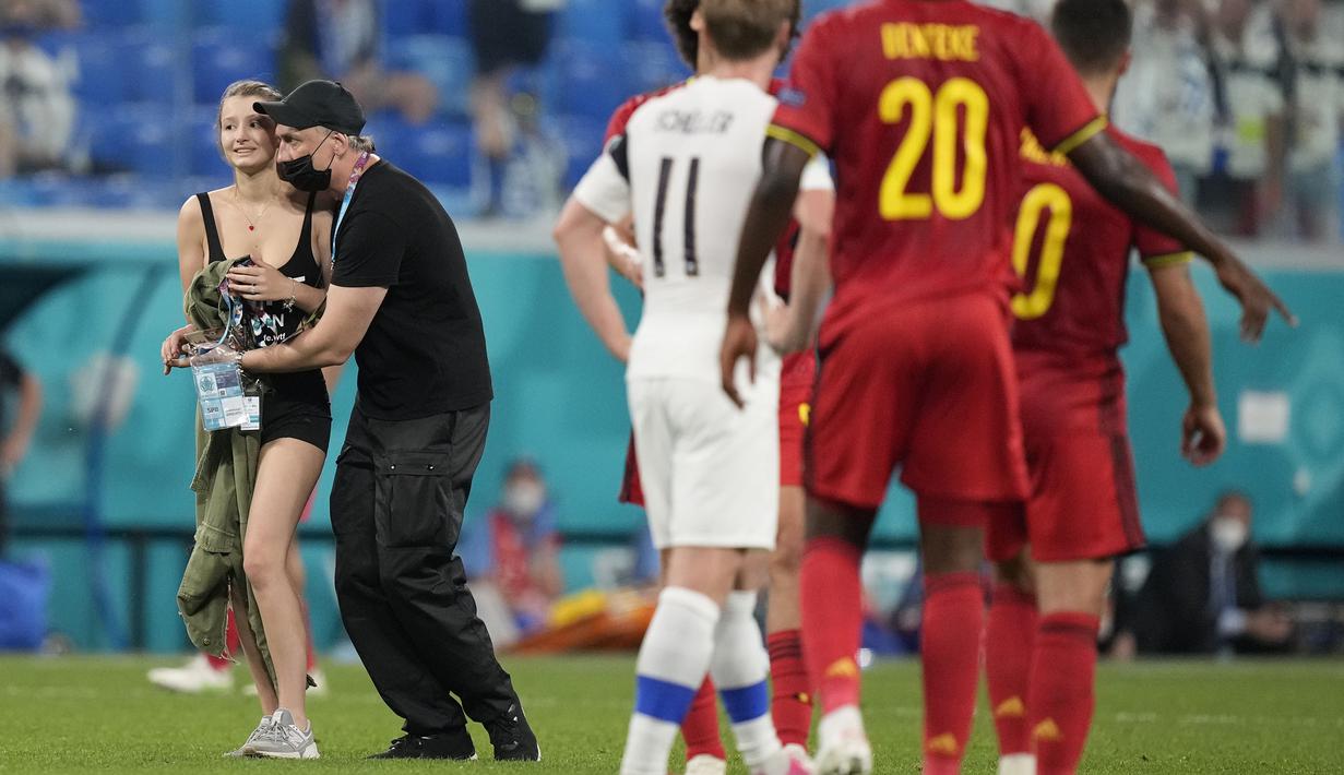 Tak berapa lama kemudian, salah satu petugas keamanan berhasil menangkap wanita tersebut dan membawanya ke luar lapangan. (Foto: AP/Pool/Dmitri Lovetsky)