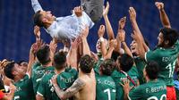 Para pemain Timnas Meksiko mengangkat sang pelatih, Jaime Lozano, berselebrasi setelah mengalahkan Jepang pada perebutan medali perunggu di sepak bola Olimpiade Tokyo, Kamis (6/8/2021). (AP Photo/Martin Mejia)