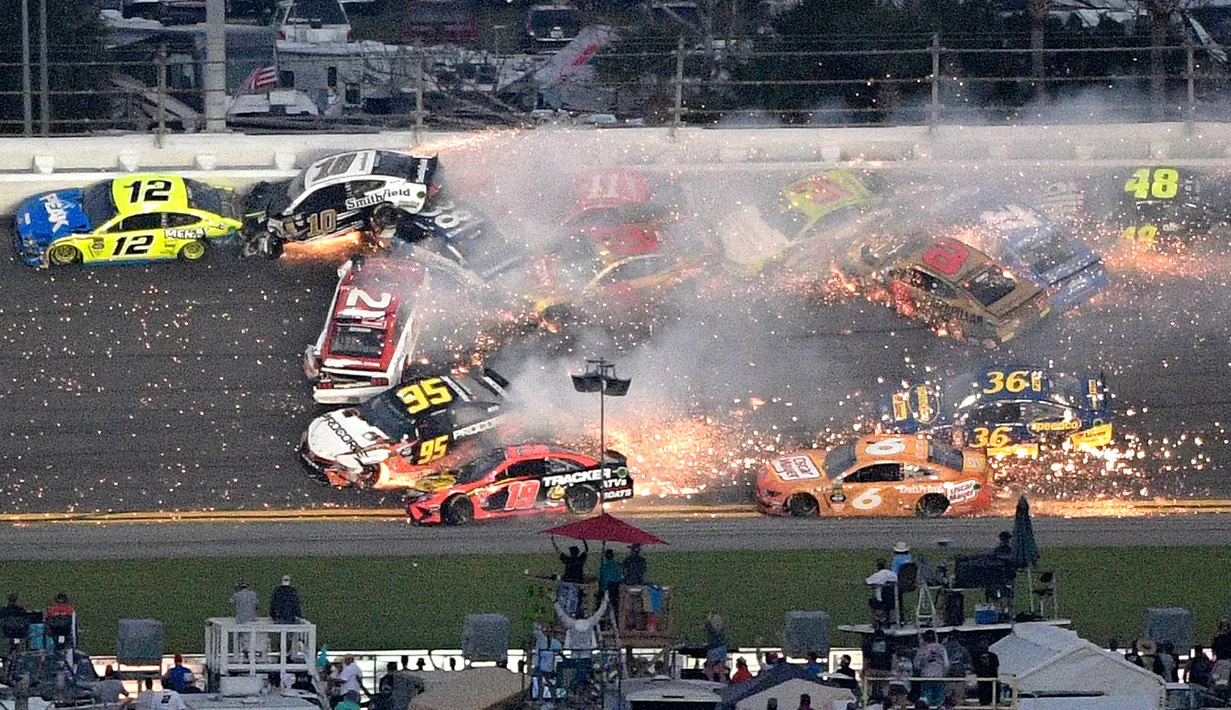 Sejumlah mobil terlibat kecelakaan dalam balapan NASCAR Daytona 500 di Daytona International Speedway, Daytona Beach, Florida, AS, Minggu (17/2). Kecelakaan tersebut dipicu oleh Paul Menard. (AP Photo/Phelan M. Ebenhack)