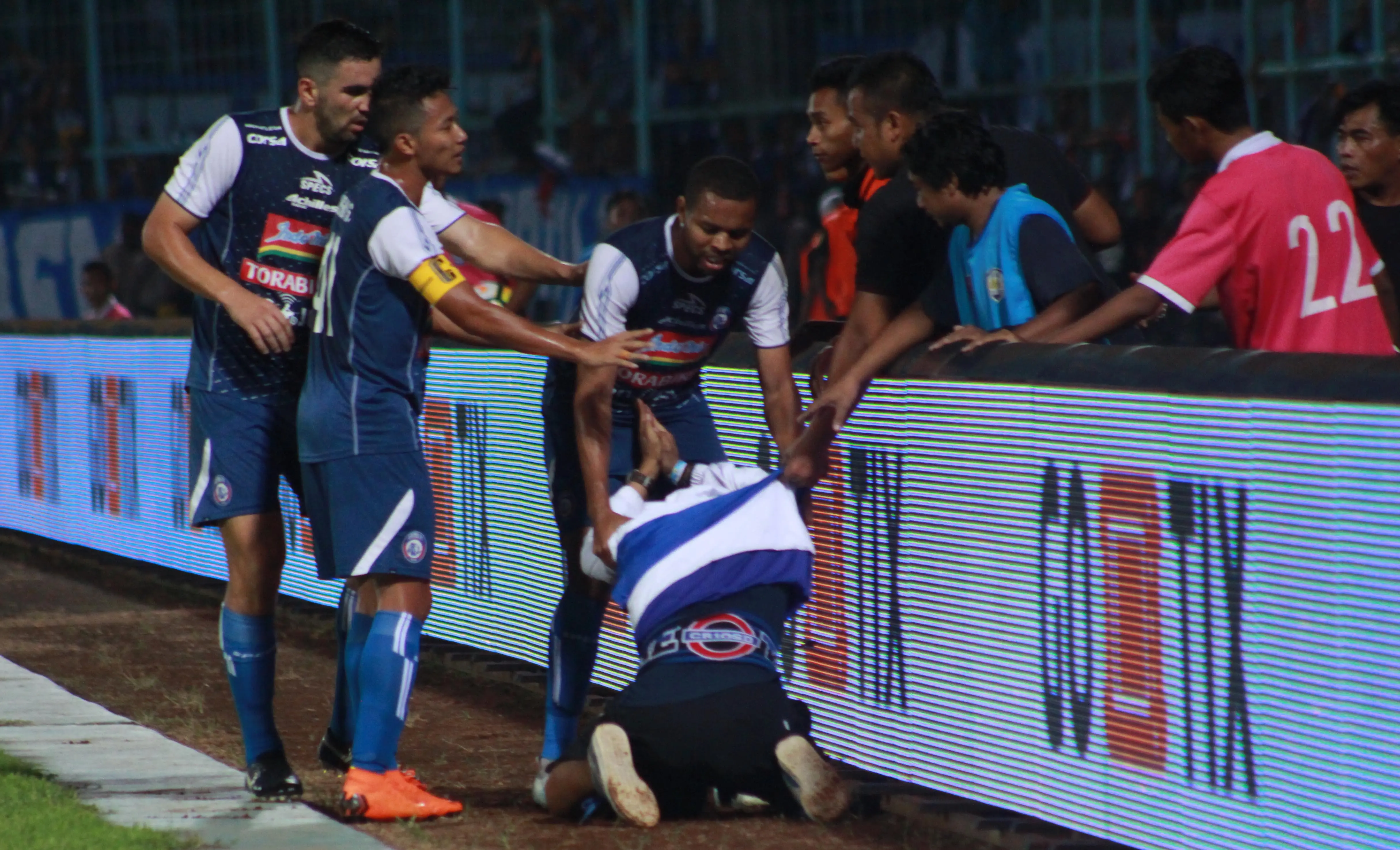 Pemain Arema FC mengembalikan seorang suporter yang mencoba masuk lapangan saat duel kontra Persib Bandung, Minggu (16/4/2018) di Stadion Kanjuruhan. (Bola.com/Iwan Setiawan)