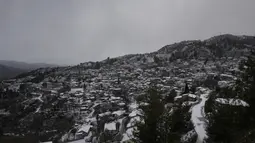 Salju menutupi rumah-rumah saat hujan salju di desa Kyperounta di gunung Troodos, pulau Mediterania tenggara Siprus, Rabu (19/1/2022). Siprus berada dalam cengkeraman badai pertengahan musim dingin yang membawa hujan lebat, suhu rendah, dan salju masuk pegunungan Troodos. (AP Photo/Petros Karadjias)