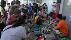 Warga mengisi daya ponsel mereka secara gratis di sebuah mal saat sebagian besar kota Cebu masih tanpa listrik akibat Topan Rai, Sabtu (18/12/2021). Badai menghantam beberapa daerah berpenduduk padat, termasuk Cebu Kamis malam, satu kota berpenduduk hampir 1 juta orang. (AP/Jay Labra)
