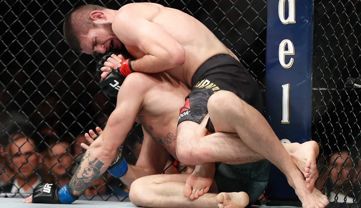 Khabib Nurmagomedov saat mengunci Conor McGregor dalam pertarungan UFC 229 di Las Vegas, AS (6/10). Nurmagomedov dinyatakan menang melalui submission. Dia melakukan rear naked choke kepada McGregor. (AP Photo/John Locher)