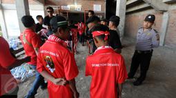 Petugas kepolisian mengawasi proses pemeriksaan suporter di depan pintu masuk Stadion I Wayan Dipta, Gianyar, Bali, Minggu (30/8/2015). Jelang pembukaan turnamen Piala Presiden 2015, ribuan suporter menyerbu stadion. (Liputan6.com/Helmi Fithriansyah) 