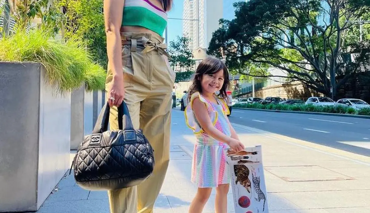 Seperti penampilannya satu ini, berpose di trotoar jalan, Acha Septriasa tampil chic memadukan cut out crop top dengan cargo pants serta sepatu boots. Sementara putrinya, Bridgia tampil manis mengenakan baju warna-warni. (Instagram/septriasaacha).