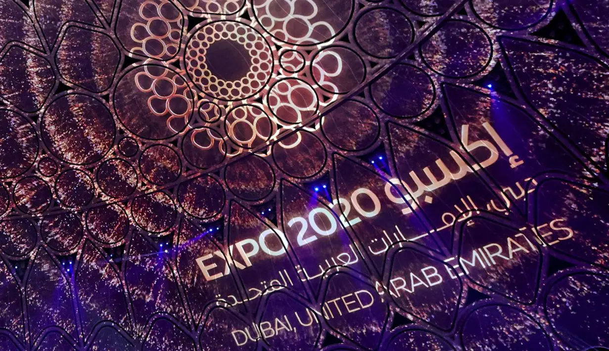 Sebuah logo Dubai Expo 2020 diproyeksikan pada upacara pembukaan di Dubai, Uni Emirat Arab, 30 September 2021. Pembukaan Dubai Expo 2020 berlangsung mewah dengan menampilkan kembang api dan pertunjukan lampu untuk merayu dunia meski pandemi. (GIUSEPPE CACACE/AFP)