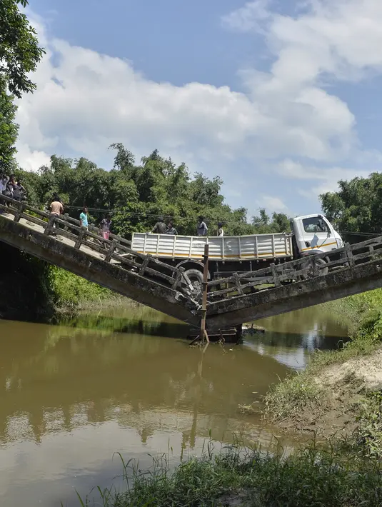 Sebuah truk berada di jembatan yang roboh di desa Phasidewa dekat perbatasan India-Bangladesh di pinggiran Siliguri di negara bagian India, Bengal Barat (7/9). Tidak ada korban dalam kejadian jembatan roboh tersebut. (AFP Photo/Diptendu Dutta)
