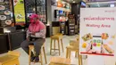 Pengemudi pengantar makanan foodpanda menunggu pesanan dari kios makanan di pusat perbelanjaan di Bangkok, Selasa (4/5/2021). Operator pengiriman makanan online di Thailand meningkat saat restoran diperintahkan hanya memberikan layanan take away di tengah gelombang Covid-19 terbaru (Jack TAYLOR/AFP)