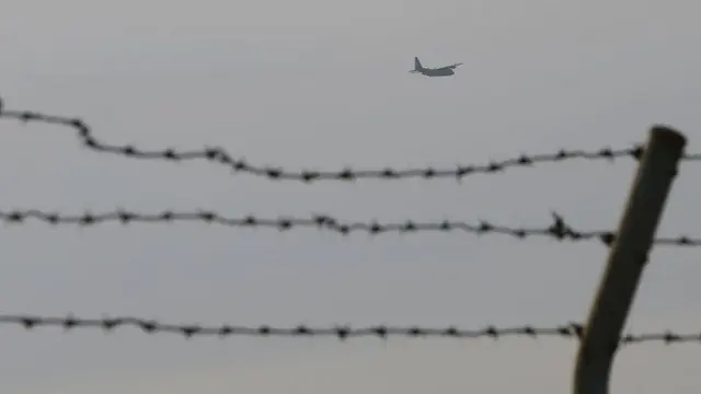 Pesawat C-130 milik AS terbang di langit Fussa, tempat Yokota Air Base berada (Koji Ueda/AP)