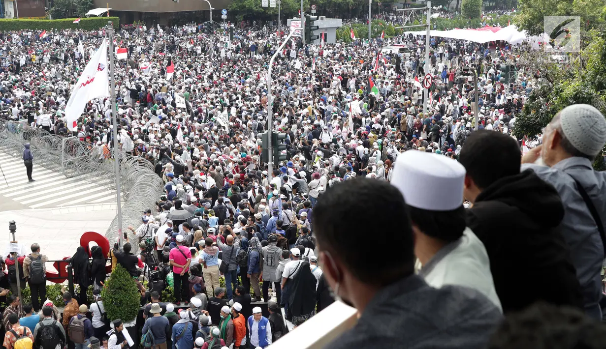 Warga melihat kerumunan peserta aksi massa Gerakan Nasional Kedaulatan Rakyat yang melakukan unjuk rasa di perempatan dekat Gedung Bawaslu, Jakarta, Rabu (22/5/2019). Dalam aksinya, mereka meminta Bawaslu memeriksa kembali hasil Pemilu 2019. (Liputan6.com/Helmi Fithriansyah)