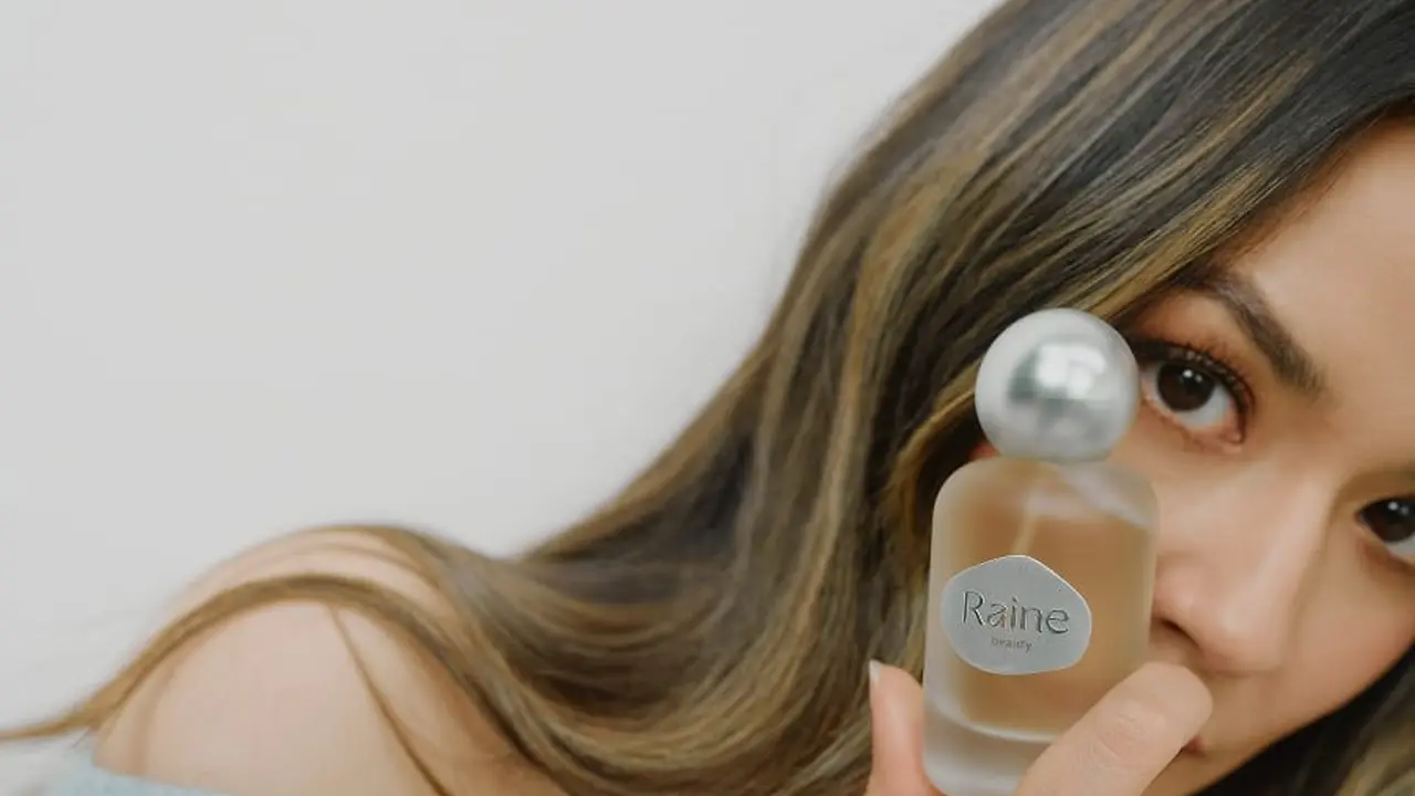 Ilustrasi Raisa Memegang Parfum Ambivert/Raine Beauty