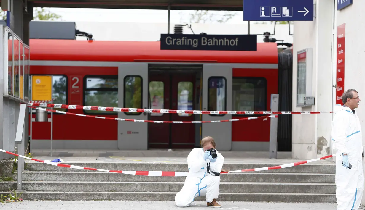 Polisi mengambil gambar di lokasi penyerangan di stasiun kereta komuter S-Bah di Grafing, kota di Munich, Jerman selatan, Selasa (10/5). Penikaman yang dilakukan seorang pria berusia 27 tahun itu dilaporkan menewaskan satu orang. (REUTERS/Michaela Rehle)