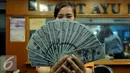 Petugas memperlihatkan uang pecahan US$100 di penukaran uang, Jakarta, Rabu (12/8/2015). Reshuffle kabinet pemerintahan Jokowi-JK, nilai Rupiah terahadap Dollar AS hingga siang ini menembus Rp 13.849. (Liputan6.com/Johan Tallo)