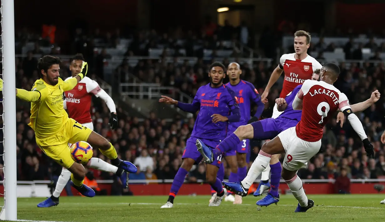 Striker Arsenal, Alexandre Lacazette, berusaha membobol gawang Liverpool yang dijaga Alisson Becker pada laga Premier League di Stadion Emirates, London, Minggu (3/11). Kedua klub bermain imbang 1-1. (AFP/Ian Kington)