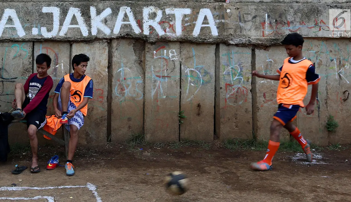 Warga bermain dalam kompetisi sepak bola di pinggir Kali Banjir Kanal Barat, Jakarta, Sabtu (5/11). Minimnya sarana untuk bermain sepak bola mengakibatkan warga terpaksa memanfaatkan lahan di pinggir kali tersebut untuk bermain.Liputan6.com/JohanTalllo