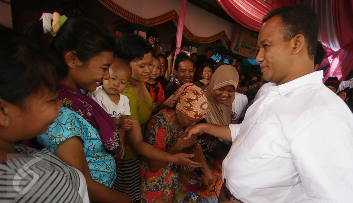 Warga bersalaman dengan Calon gubernur DKI Jakarta Anies Baswedan saat blusukan di Kampung Maja, Pegadungan, Jakarta Barat, Senin (7/11). (Liputan6.com/Immanuel Antonius)