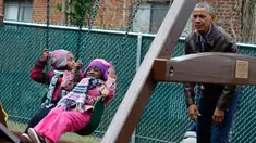 Presiden AS Barack Obama bermain ayunan dengan anak-anak dari sebuah tempat penampungan di Washington DC, AS, Selasa (16/1). Obama menyumbangkan wahana bermain milik kedua putrinya yang dipasang di luar Oval Office. (AFP PHOTO / YURI GRIPAS)