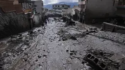 Lumpur memenuhi jalan setelah lereng bukit yang diguyur hujan runtuh dan membawa gelombang lumpur ke daerah La Gasca di Quito, Ekuador, Selasa (1/2/2022). (AP Photo/Dolores Ochoa)