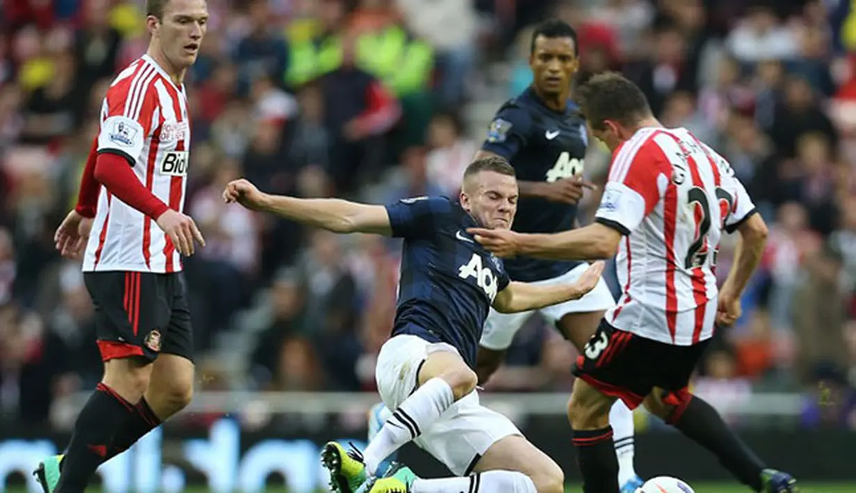 Gelandang Sunderlan Emanuele Giaccherini di hadang Tom Cleverley pada pertandingan sepak bola Liga Inggris antara Sunderland dan Manchester United di Stadion of Light di Sunderland (05/10/13). (AFP/Ian MacNicol)