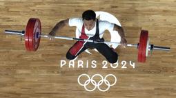 Lifter Indonesia, Eko Yuli Irawan berusaha melakukan angkatan pada cabor angkat besi Olimpiade Paris 2024 di South Paris Arena, Paris, Prancis, Rabu (07/08/2024). (AP Photo/Pool/Dita Alangkara)